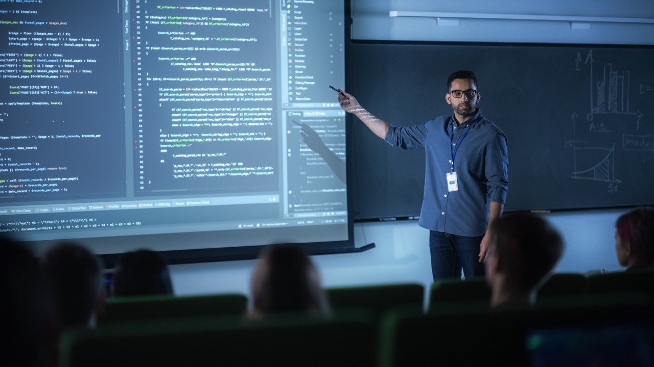Man pointing to screen with code displayed on projector