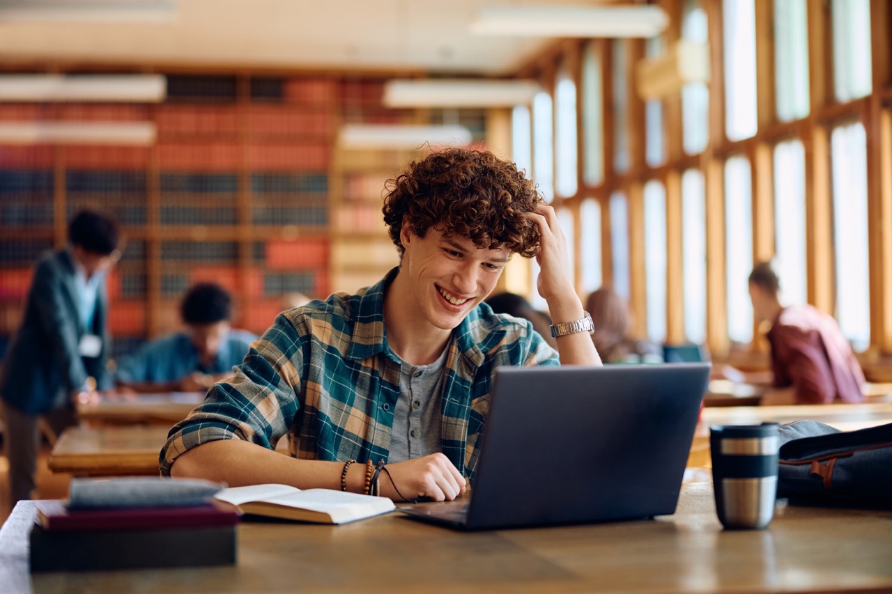 Man smiling while looking down on screen