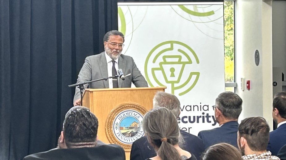Director speaking at event wearing suit and tie